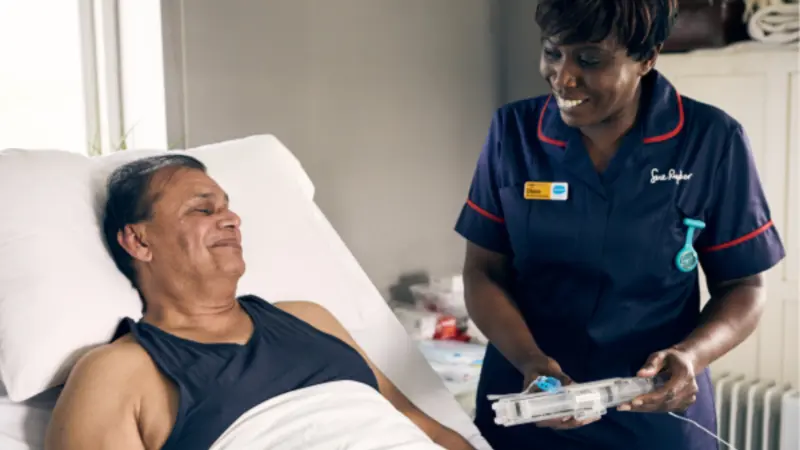Nurse showing patient a syringe driver