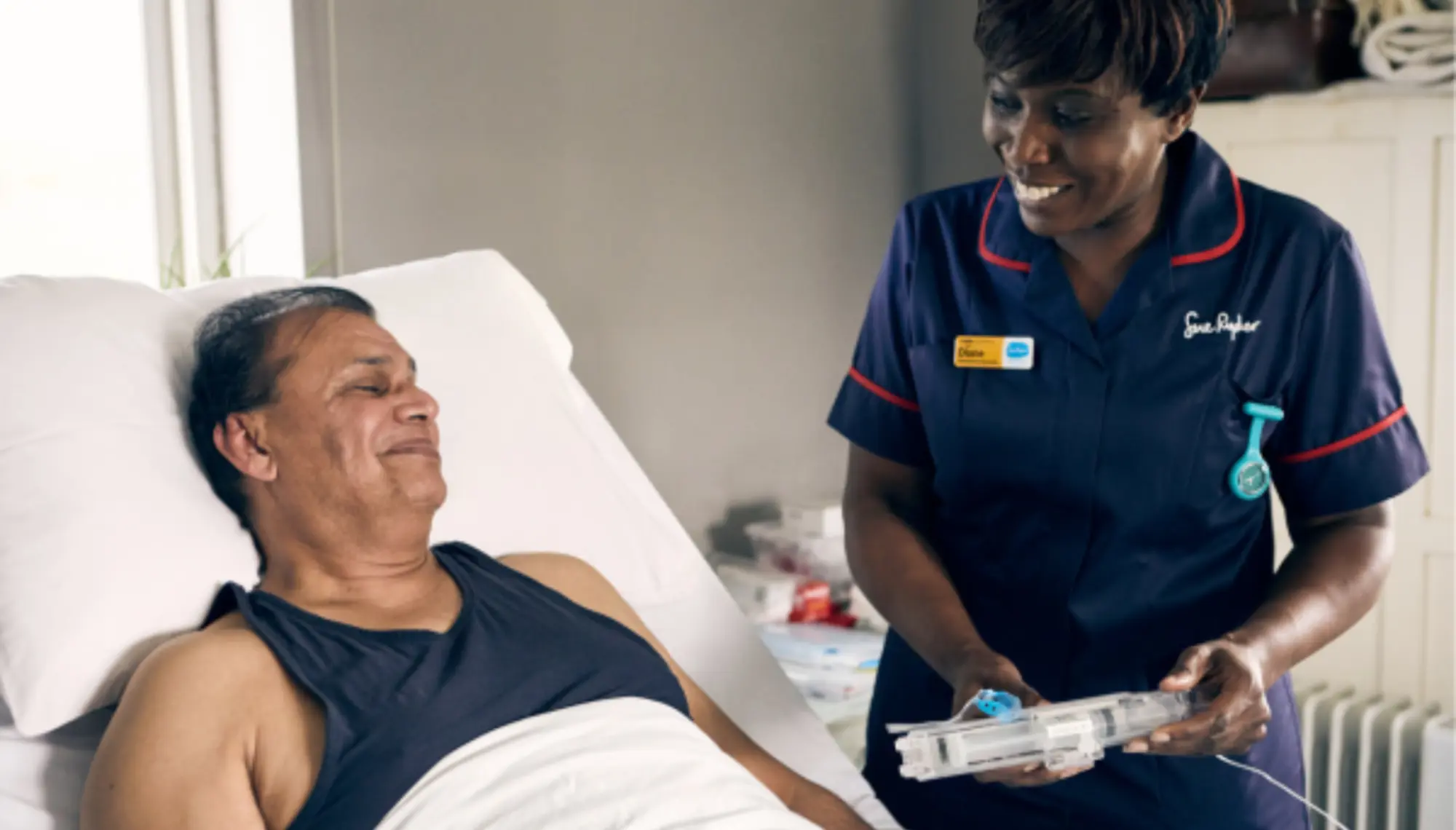 Nurse showing patient a syringe driver