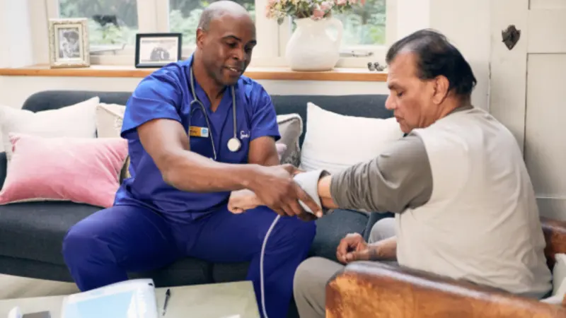 Healthcare professional taking patient blood pressure